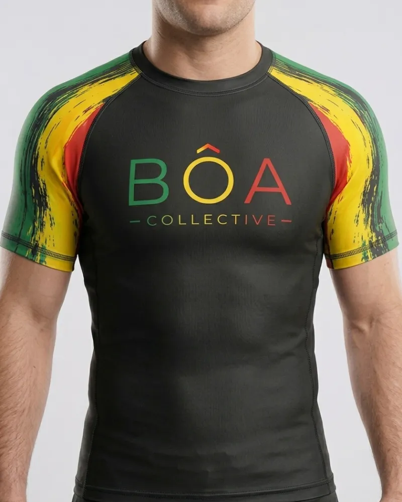 Rashguard negro de manga corta con mangas raglán verde, amarillo y rojo y el logo de BÔA Collective, frente
