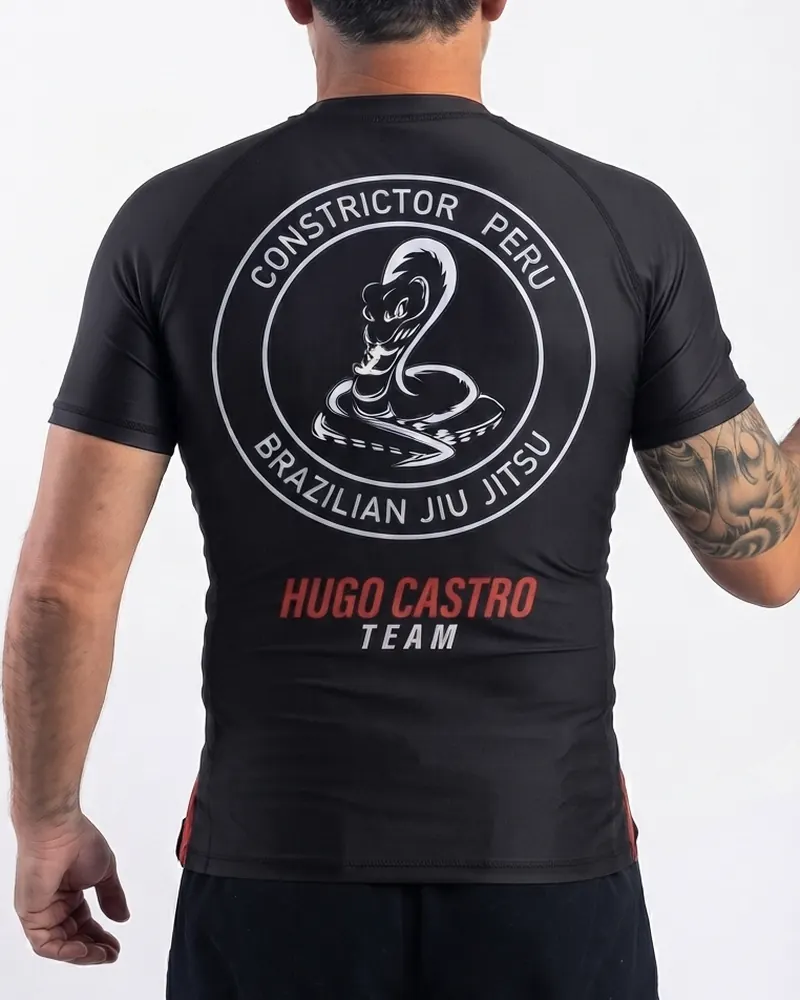 Rashguard negro con el escudo circular de Constrictor Peru y el nombre del equipo en la espalda