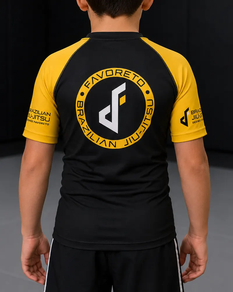Rashguard infantil negro con mangas amarillas y escudo de Favoreto en la espalda