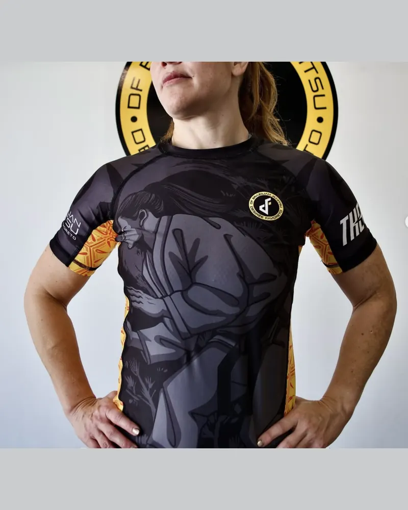 Rashguard de diseño completo con ilustración de jiu jitsu en negro, gris y amarillo, frente