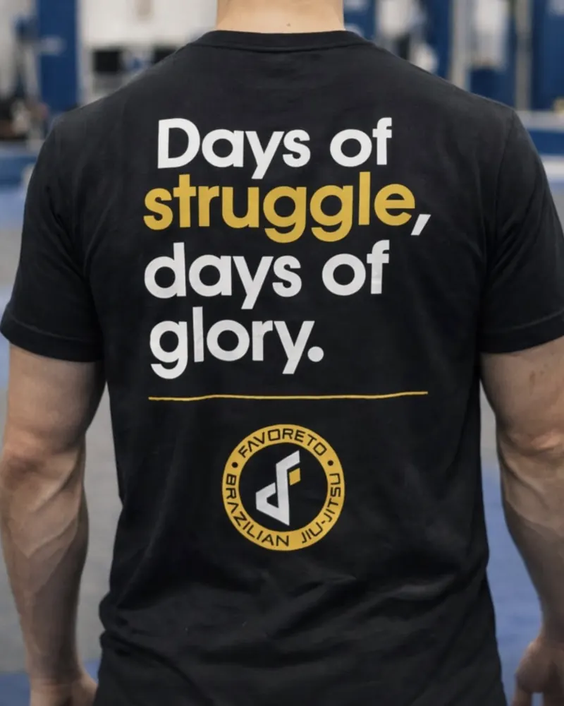 Camiseta negra con la frase “Days of struggle, days of glory” y el escudo, espalda